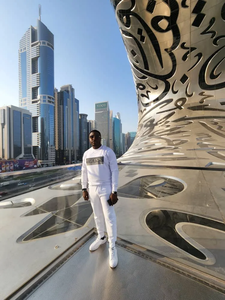 Kenny in white clothes overlooking a city skyline